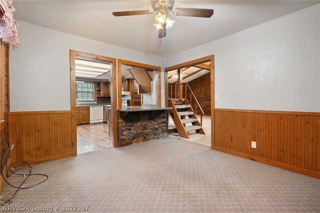 interior space featuring ceiling fan and wooden walls