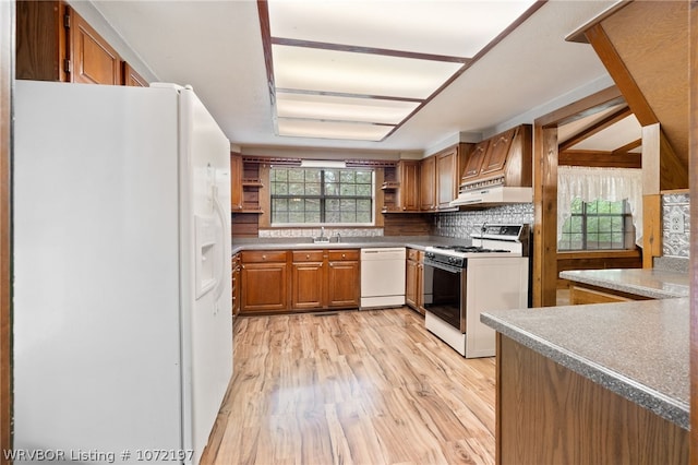 kitchen with sink, tasteful backsplash, ventilation hood, light hardwood / wood-style floors, and white appliances