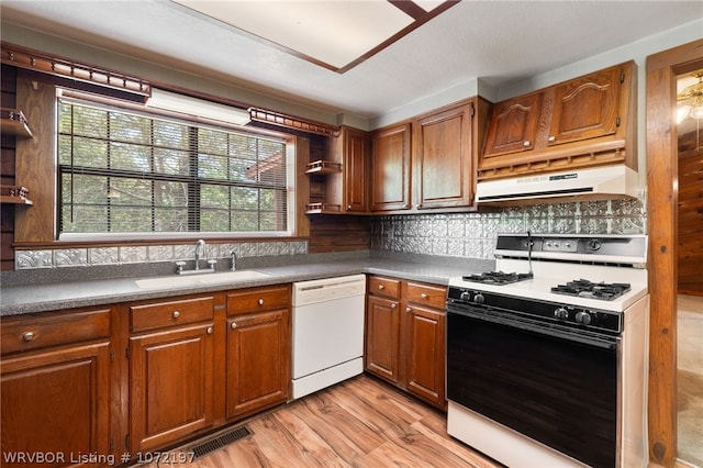 kitchen featuring backsplash, white appliances, sink, and light hardwood / wood-style flooring