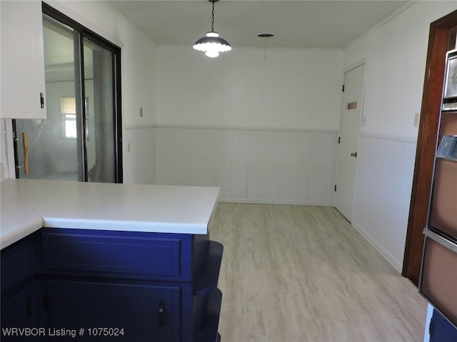 kitchen featuring blue cabinetry, pendant lighting, white cabinetry, and light hardwood / wood-style flooring