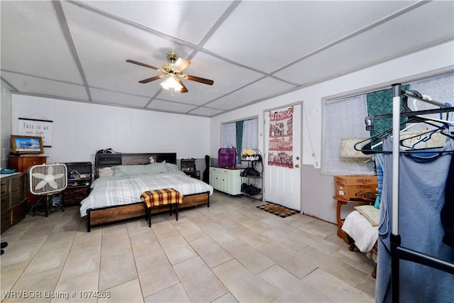 bedroom featuring a drop ceiling and ceiling fan