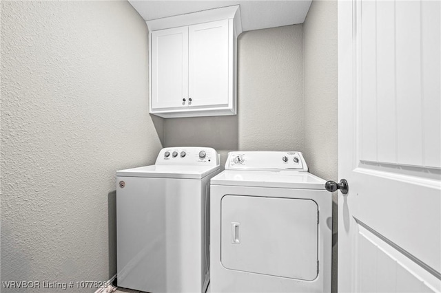 laundry room with washing machine and dryer and cabinets