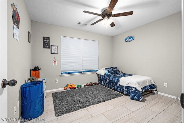 bedroom featuring ceiling fan and a textured ceiling