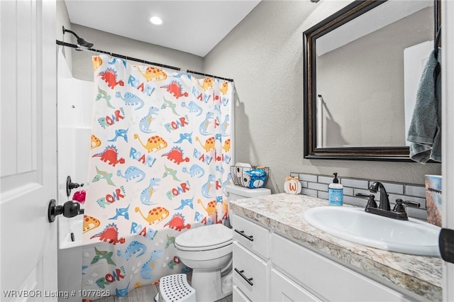 bathroom with vanity, tasteful backsplash, toilet, and walk in shower