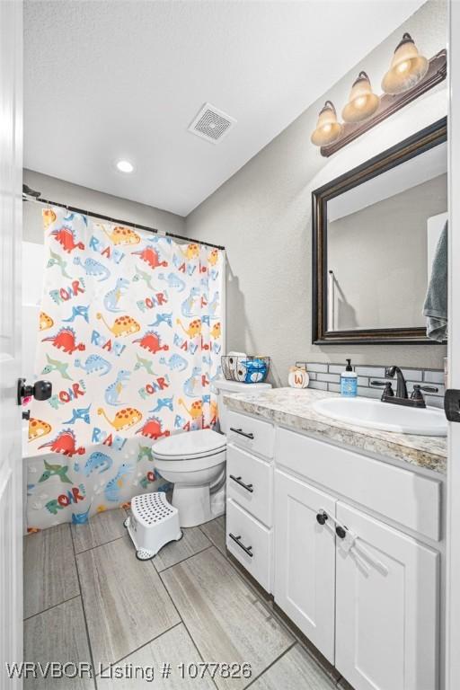 bathroom featuring vanity and toilet