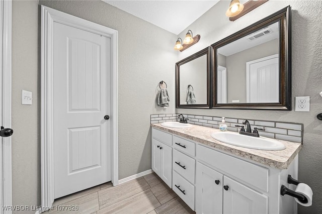 bathroom featuring vanity and backsplash