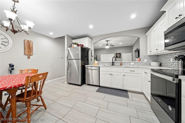 kitchen featuring white cabinets, decorative light fixtures, ceiling fan with notable chandelier, and appliances with stainless steel finishes