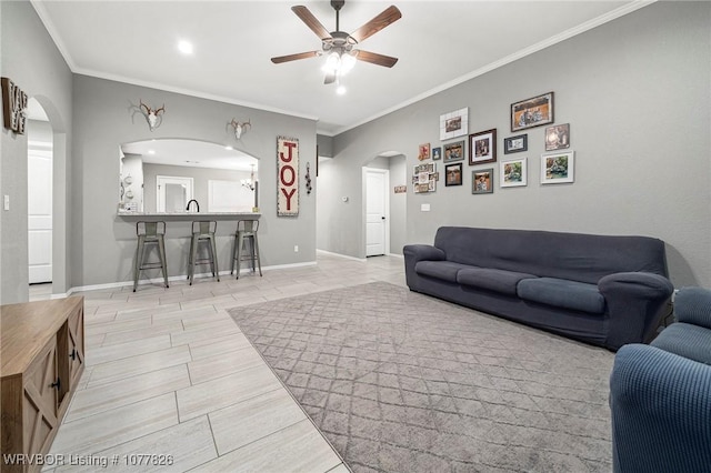 living room with ceiling fan and crown molding