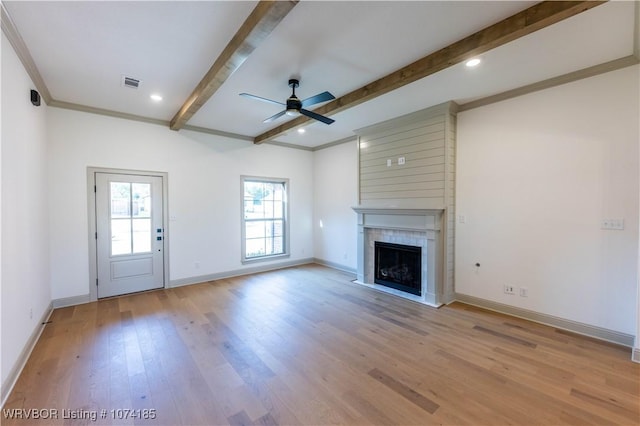 unfurnished living room with crown molding, light hardwood / wood-style flooring, ceiling fan, a fireplace, and beam ceiling