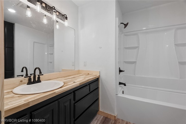 1703 E Edmondson Dr, Sallisaw, OK 74955 - bathroom with wood finished floors, vanity, washtub / shower combination, and baseboards