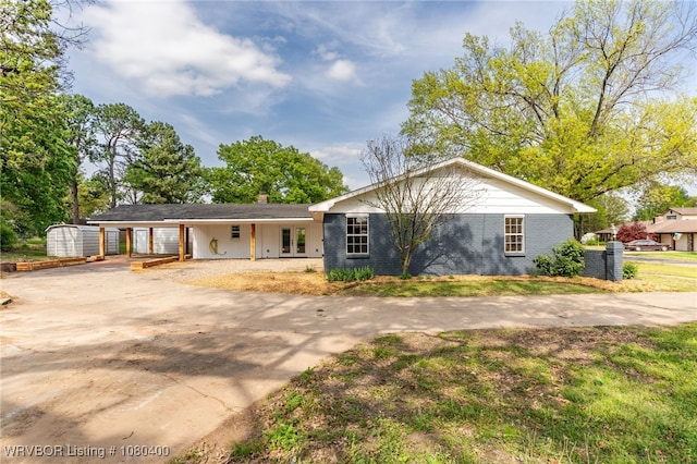 1703 E Edmondson Dr, Sallisaw, OK 74955 - ranch-style house featuring concrete driveway, a chimney, an attached carport, and brick siding