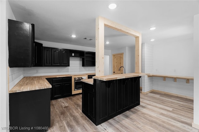 1703 E Edmondson Dr, Sallisaw, OK 74955 - kitchen with dark cabinetry, wooden counters, stainless steel oven, and recessed lighting