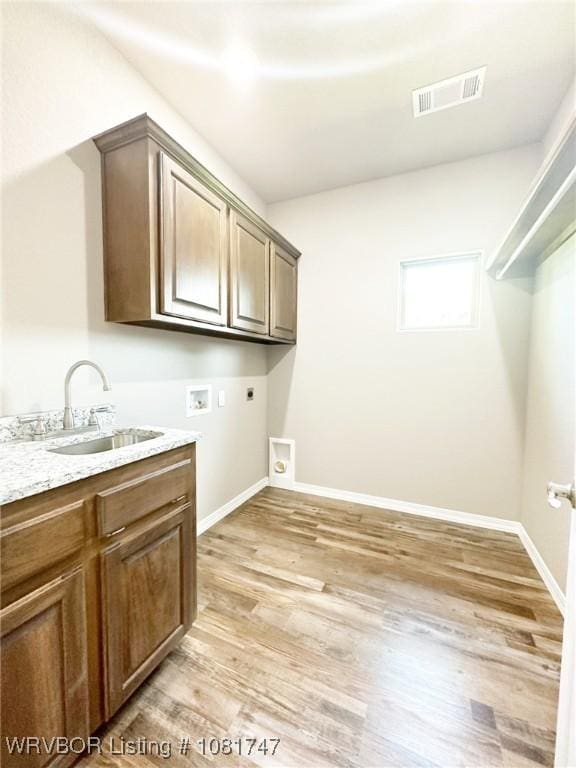 2060 W Breckenridge St, Sallisaw, OK 74955 - washroom with hookup for an electric dryer, washer hookup, light wood finished floors, and cabinet space