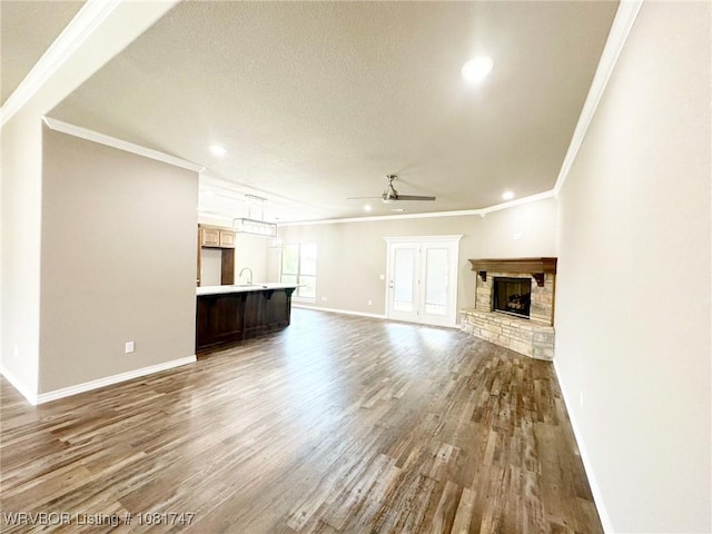 2060 W Breckenridge St, Sallisaw, OK 74955 - unfurnished living room with a ceiling fan, wood finished floors, ornamental molding, a stone fireplace, and recessed lighting
