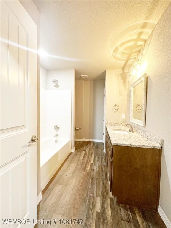 2060 W Breckenridge St, Sallisaw, OK 74955 - full bath with wood finished floors, vanity,  shower combination, and a textured ceiling