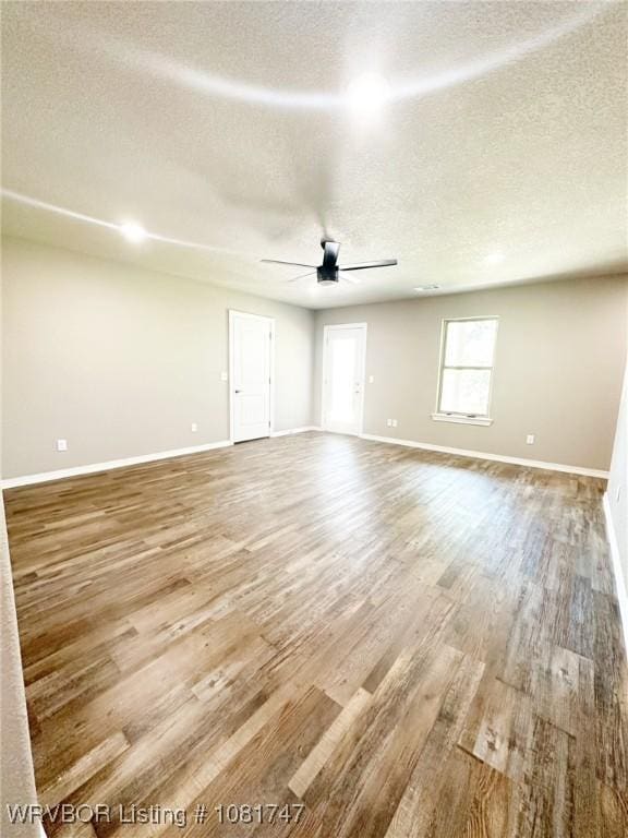 2060 W Breckenridge St, Sallisaw, OK 74955 - empty room with wood finished floors, a textured ceiling, and a ceiling fan