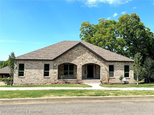 2060 W Breckenridge St, Sallisaw, OK 74955 - french country style house with a porch, brick siding, a shingled roof, and a front lawn