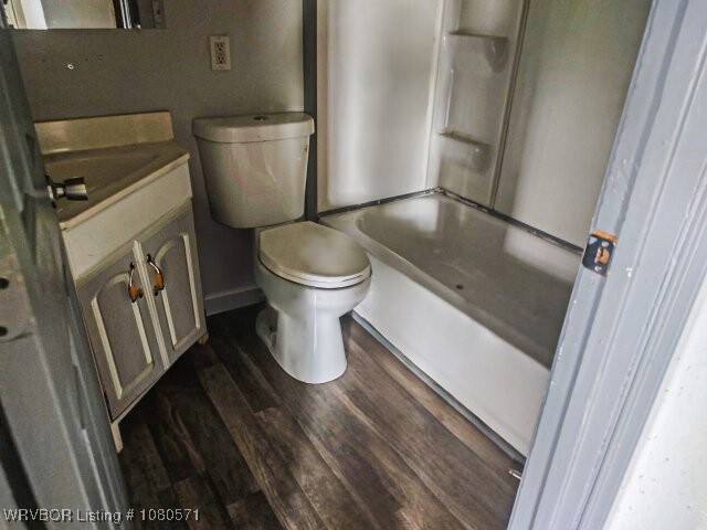 full bath with toilet, wood finished floors, vanity, and baseboards