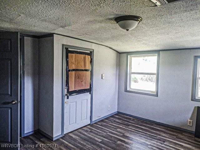 empty room with dark wood-style floors and a textured ceiling