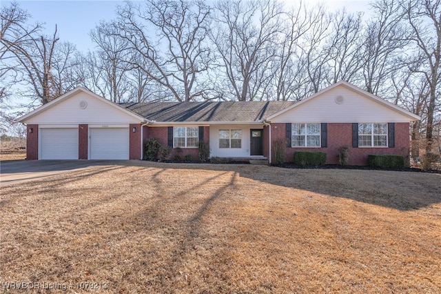 single story home featuring a front yard, brick siding, driveway, and an attached garage