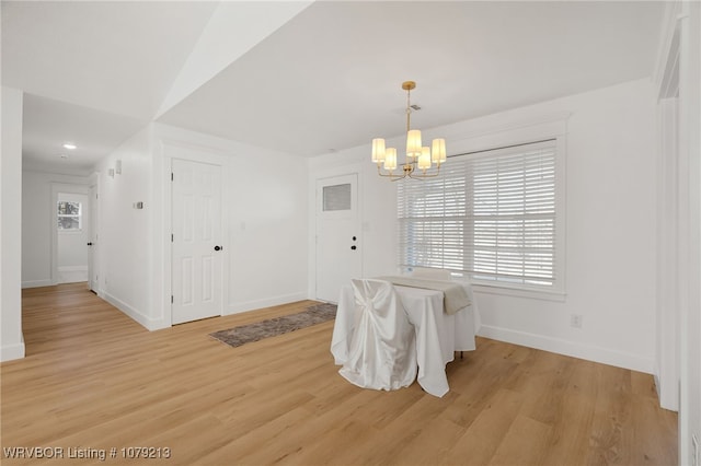 dining area featuring light wood finished floors, plenty of natural light, and a chandelier