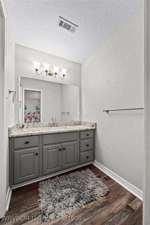 9301 Canopy Oaks Dr, Fort Smith, AR 72903 - bathroom featuring vanity, wood finished floors, a textured ceiling, and a chandelier