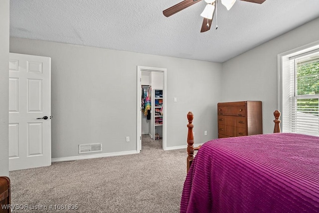 9301 Canopy Oaks Dr, Fort Smith, AR 72903 - carpeted bedroom featuring a walk in closet, a textured ceiling, a closet, and ceiling fan
