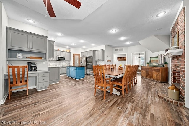 9301 Canopy Oaks Dr, Fort Smith, AR 72903 - dining room featuring ceiling fan, wood finished floors, recessed lighting, a textured ceiling, and a fireplace