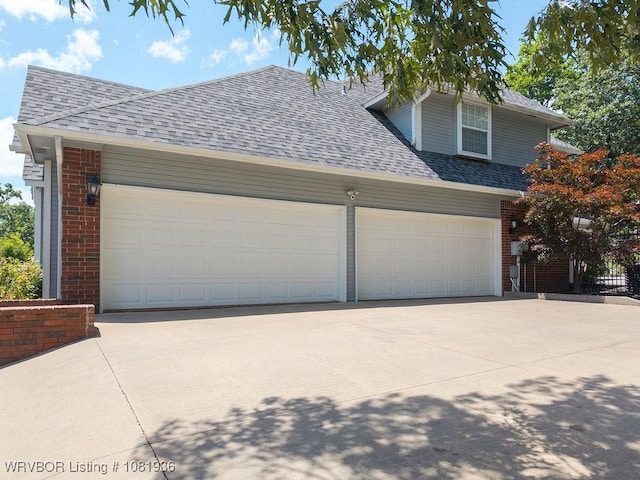 9301 Canopy Oaks Dr, Fort Smith, AR 72903 - view of front of house featuring concrete driveway, brick siding, a garage, and roof with shingles