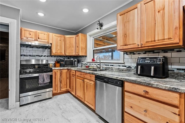 kitchen with sink, decorative backsplash, dark stone countertops, ornamental molding, and appliances with stainless steel finishes