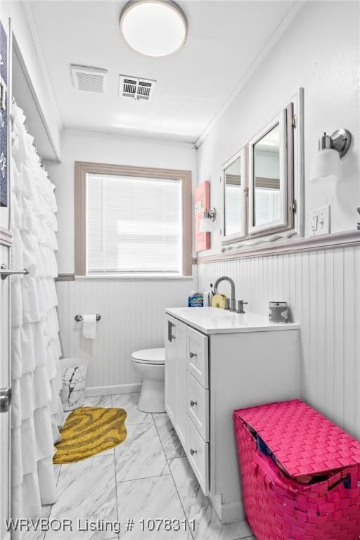 bathroom with vanity, toilet, and ornamental molding