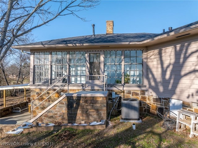 back of property featuring central AC unit and a sunroom