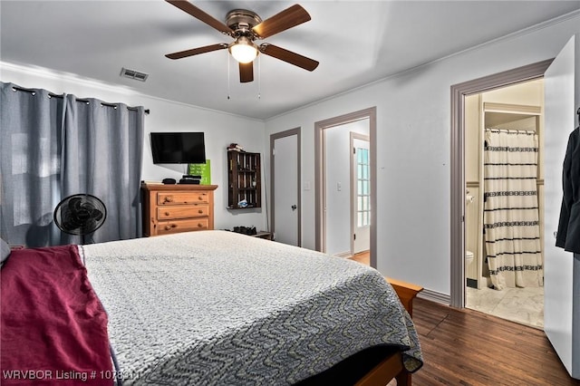 bedroom featuring ceiling fan, dark hardwood / wood-style flooring, and ensuite bath