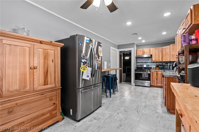 kitchen featuring wood counters, ceiling fan, appliances with stainless steel finishes, and tasteful backsplash