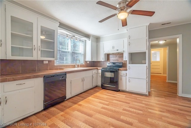 kitchen with sink, white cabinetry, and black appliances