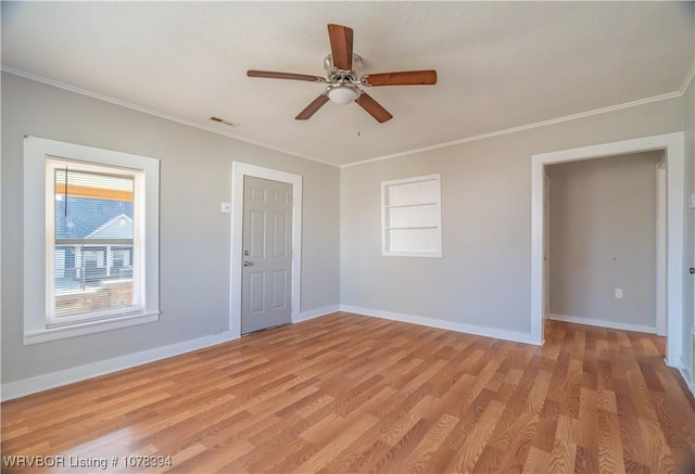 empty room with light hardwood / wood-style floors, ceiling fan, built in shelves, and ornamental molding