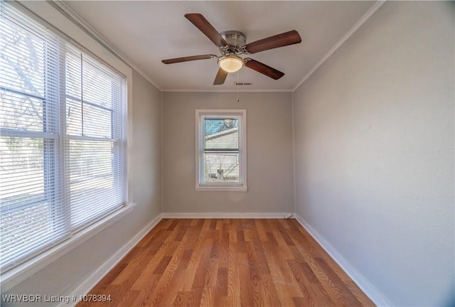 empty room with ceiling fan, ornamental molding, and light hardwood / wood-style floors