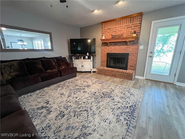 801 Northview Dr, Van Buren, AR 72956 - living room with wood finished floors, plenty of natural light, a brick fireplace, and a textured ceiling