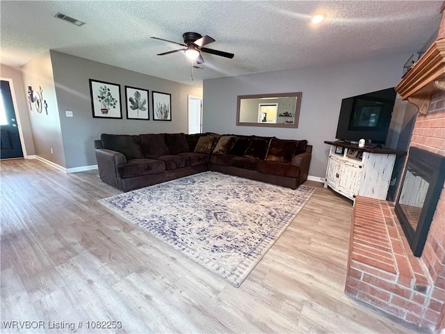 801 Northview Dr, Van Buren, AR 72956 - living room with wood finished floors, ceiling fan, a textured ceiling, and a fireplace