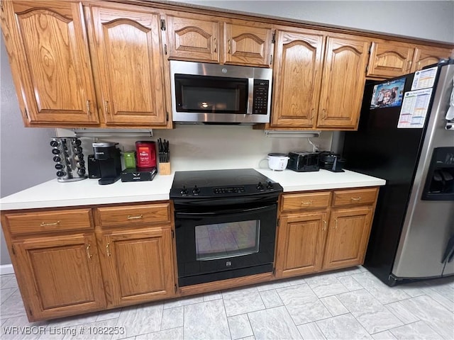 801 Northview Dr, Van Buren, AR 72956 - kitchen with stainless steel microwave, black range with electric cooktop, refrigerator with ice dispenser, light countertops, and brown cabinets