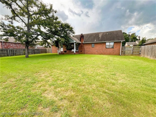 801 Northview Dr, Van Buren, AR 72956 - back of property featuring brick siding, a chimney, and a fenced backyard