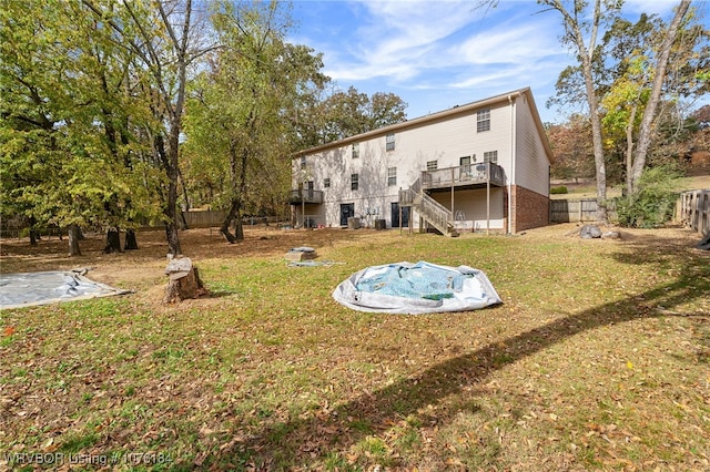 back of house featuring a lawn and a wooden deck