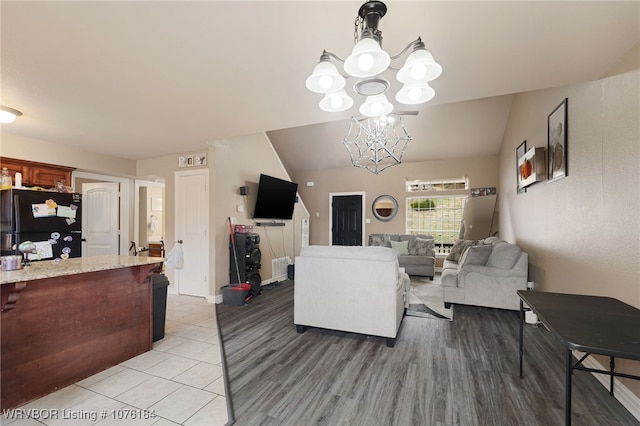 living room featuring a chandelier and lofted ceiling