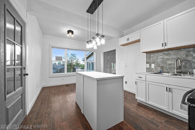 802 N 11th St, Van Buren, AR 72956 - kitchen featuring backsplash, white cabinetry, dark wood-type flooring, decorative light fixtures, and a kitchen island