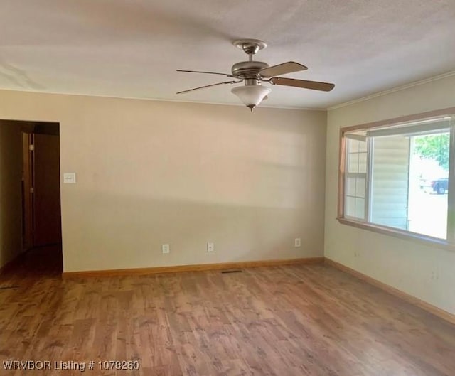 spare room with ceiling fan, crown molding, and light hardwood / wood-style floors