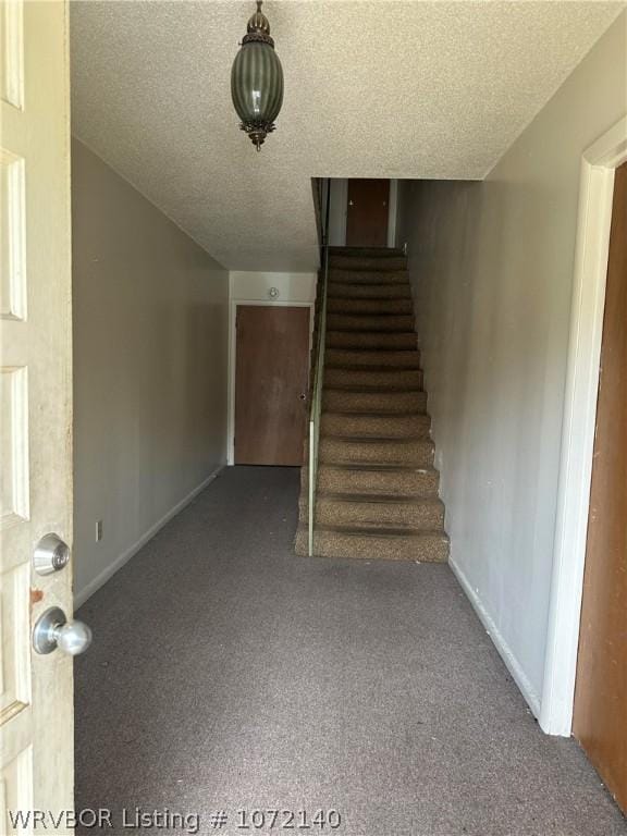 stairs with carpet flooring and a textured ceiling