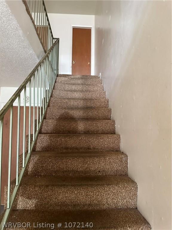 stairs with a textured ceiling