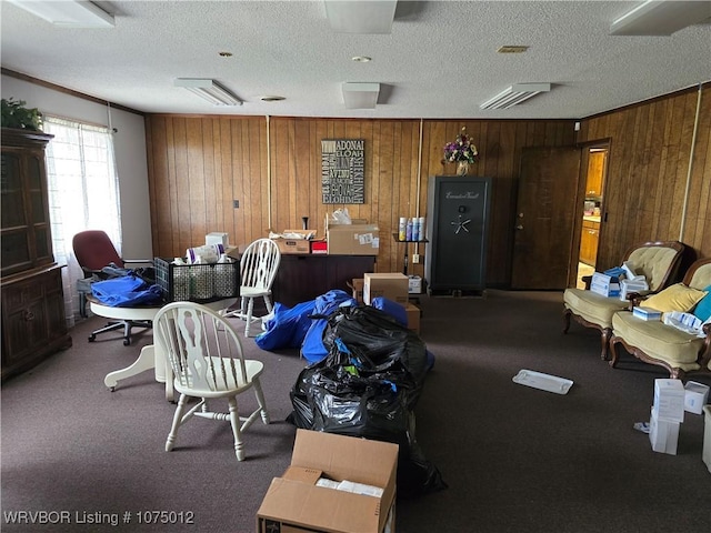 misc room with carpet, a textured ceiling, wooden walls, and crown molding