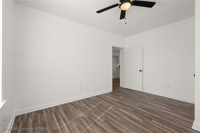 spare room with ceiling fan, wood finished floors, and baseboards