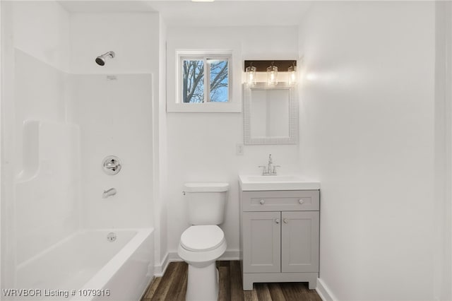 full bathroom with baseboards, toilet, vanity, wood finished floors, and shower / bathtub combination